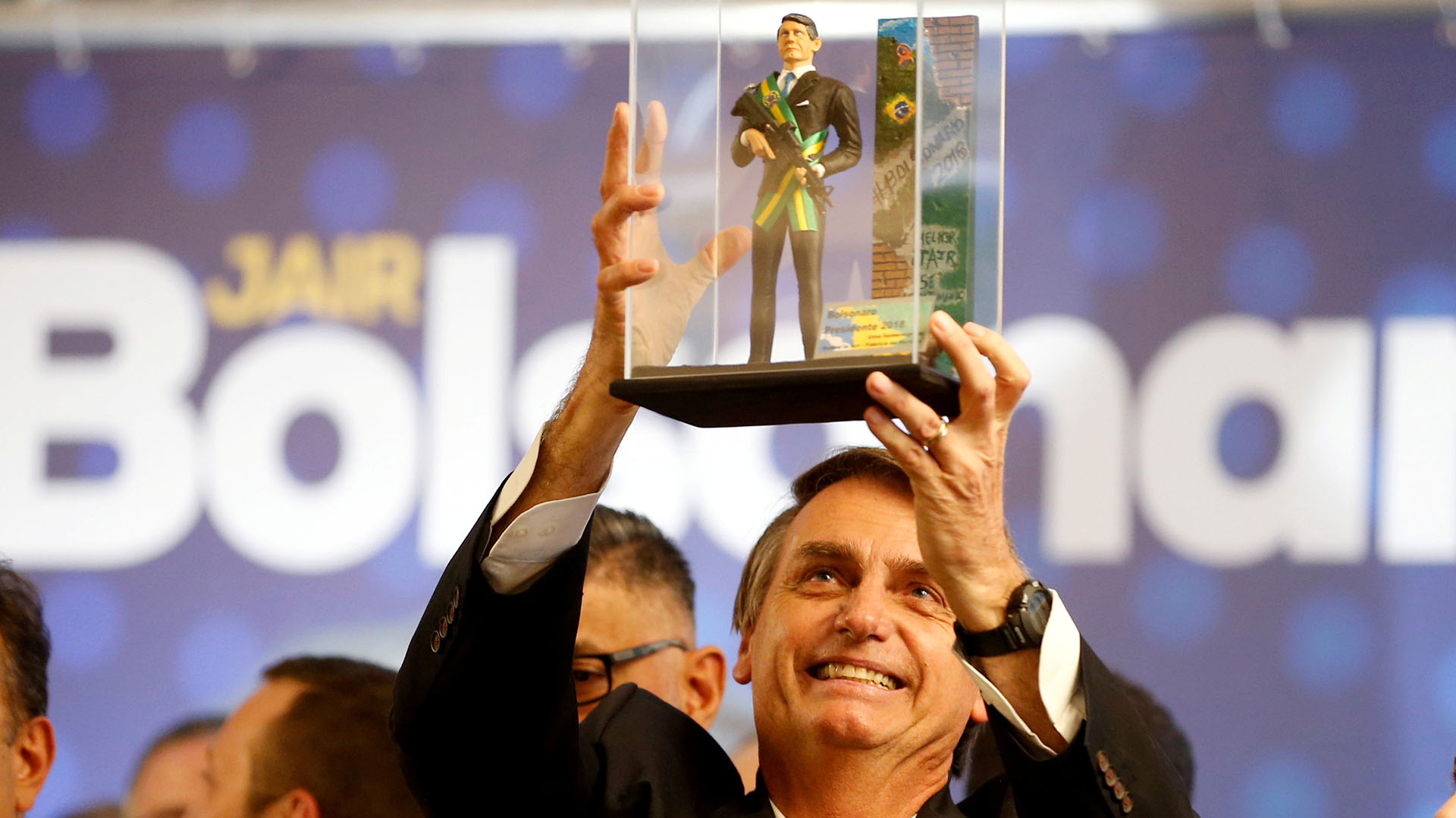 Jair Bolsonaro levanta un muñeco de él con la banda presidencial, sosteniendo un fusil de asalto, durante un acto en Curitiba en marzo pasado (REUTERS/Rodolfo Buhrer/File photo)