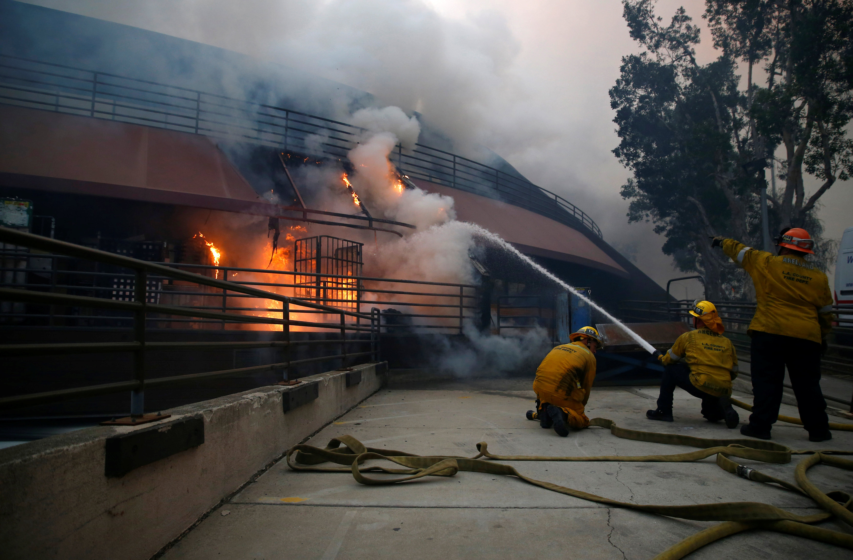 Bomberos luchan contra las llamas en una casa incendiada. REUTERS/Eric Thayer