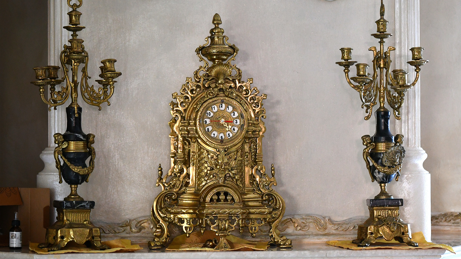 Un reloj y candelabros dorados, parte de los objetos de las propiedades que serán demolidas (Photo by Alberto PIZZOLI / AFP)