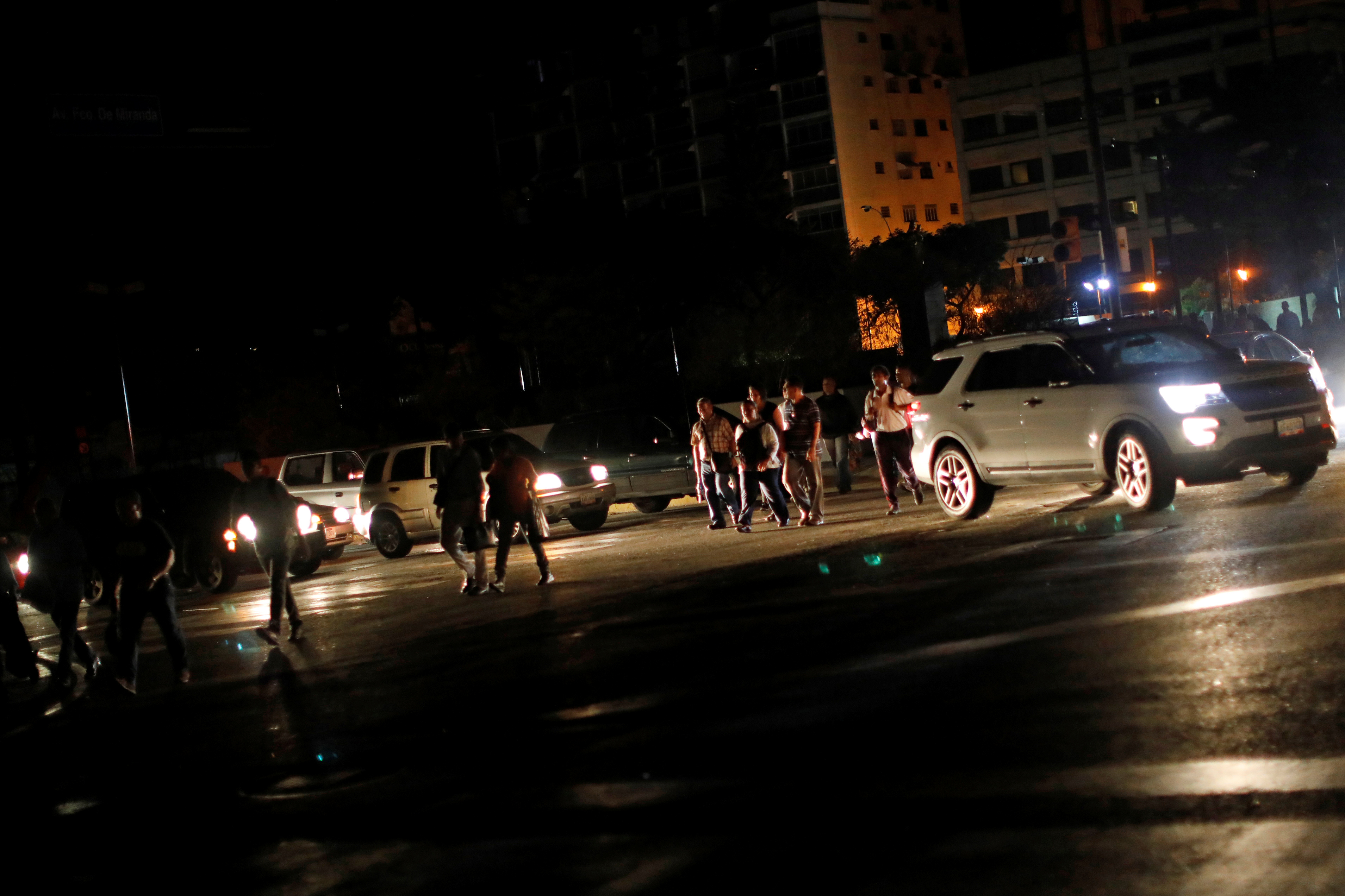 Personas caminando por una calle a oscuras en Caracas. (REUTERS/Carlos Jasso)